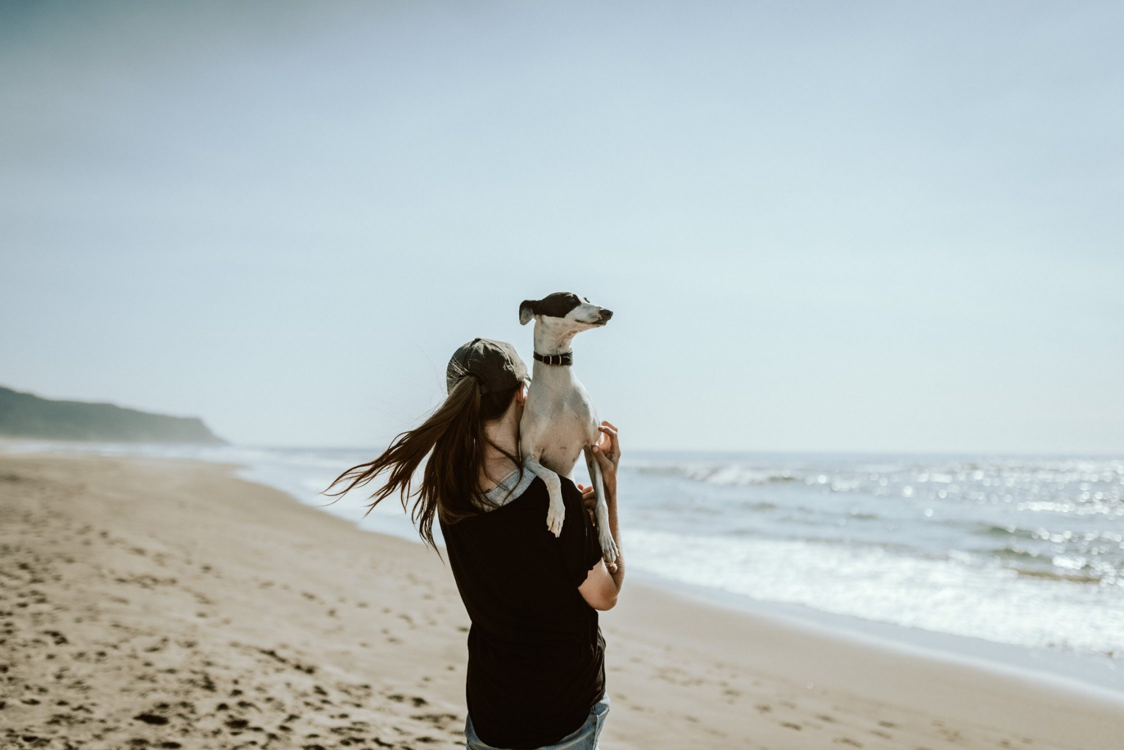 Eine Frau mit ihrem Hund am Strand.